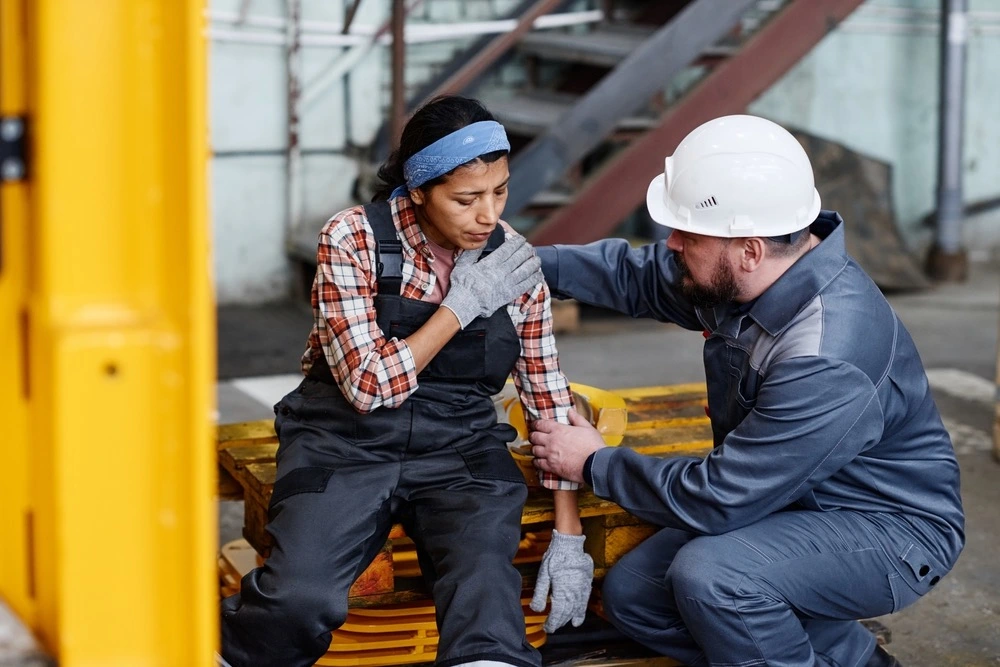Trabajador lesionado en una obra que recibe asistencia, lo que ilustra las reclamaciones por accidentes laborales contra terceros en Brownsville.