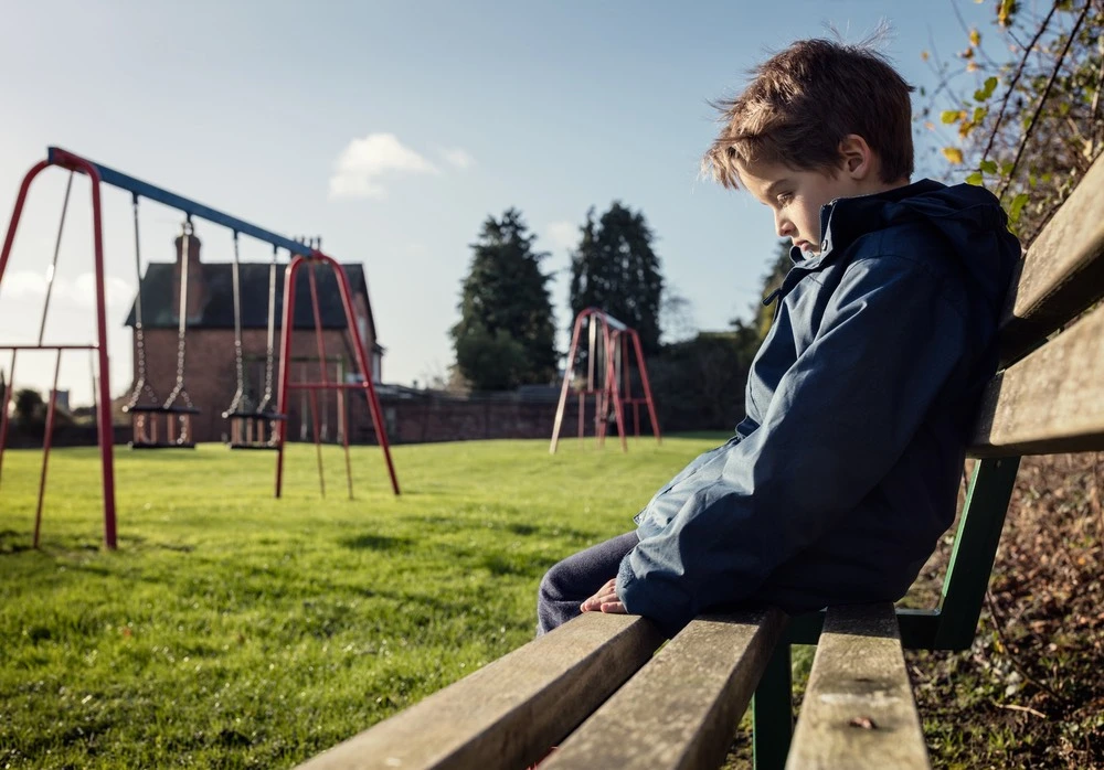Un niño solo en un parque infantil, que ilustra las protecciones legales especiales que la legislación de Texas otorga a los menores.