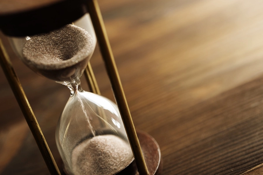Hourglass on a desk, symbolizing how long you have to file an amputation injury claim and the importance of legal deadlines.