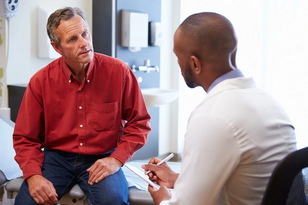 Patient discussing symptoms with a doctor during a clinical examination, illustrating the medical diagnosis and treatment process for whiplash injuries.