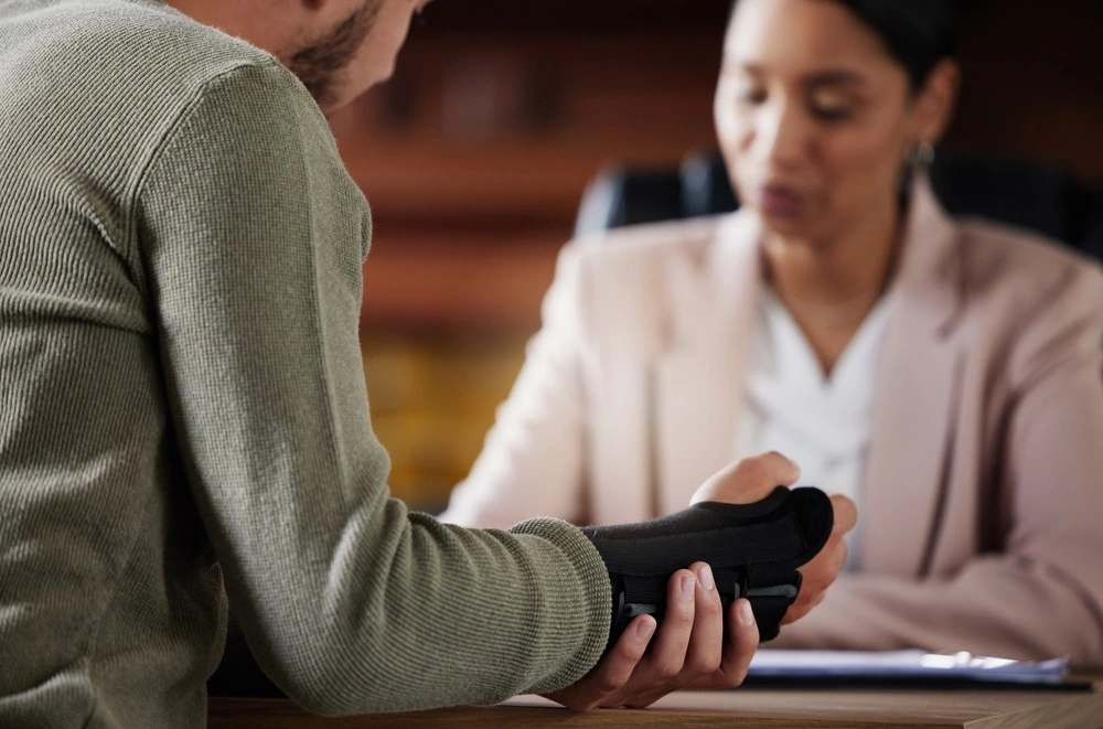 Injured person consulting with a Dallas personal injury lawyer in an office, illustrating your rights after an injury in Dallas and the steps to protect your claim.
