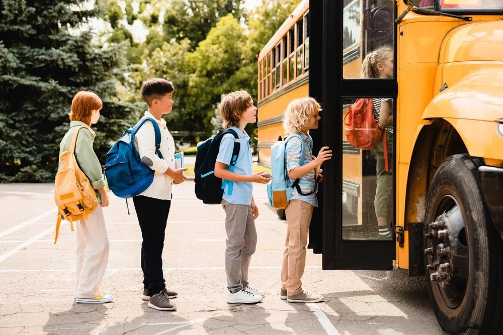 Children boarding a school bus at a stop, illustrating school bus and charter bus accidents in Houston.