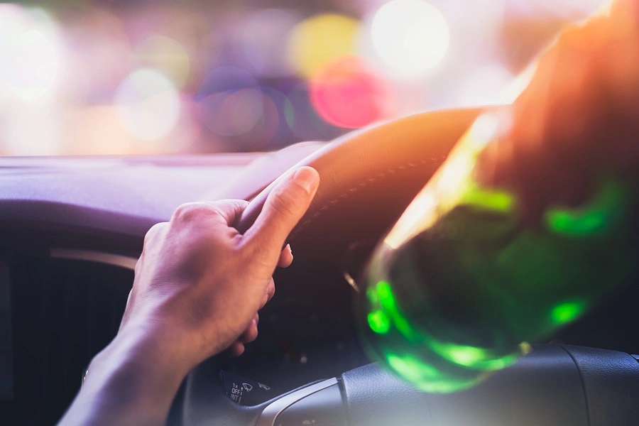 Conductor que consume alcohol al volante, lo que ilustra cómo los casos de accidentes por conducir bajo los efectos del alcohol son diferentes en Houston debido al mayor riesgo y a las consecuencias legales.