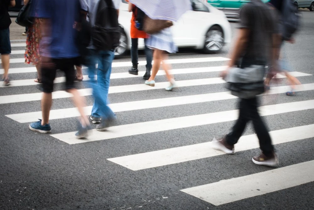 Pedestrians crossing a busy street in Harlingen, illustrating how pedestrian accidents can occur in local traffic conditions.