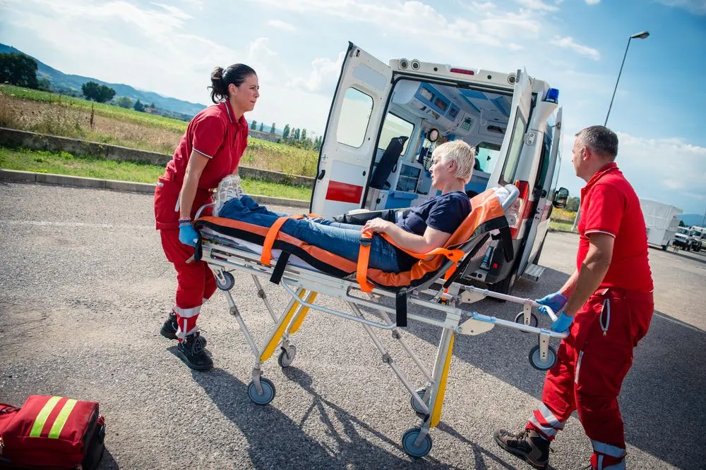 First responders transporting an injured person on a stretcher, illustrating the catastrophic injuries that can result from Harlingen truck accidents.