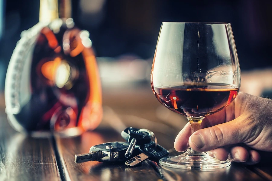 Person drinking at a bar with car keys on the table, illustrating Texas Dram Shop Law and how bars and restaurants can be held accountable for over-serving alcohol.
