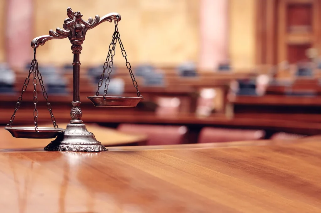 Scales of law and justice displayed in a courtroom setting, illustrating Texas premises liability laws and legal responsibilities for property owners.