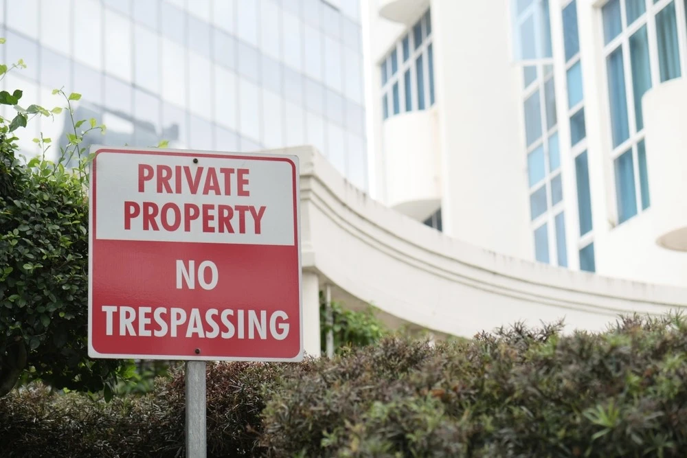 Private property sign posted near a building entrance, illustrating questions about who can be held liable for injuries on someone else’s property.