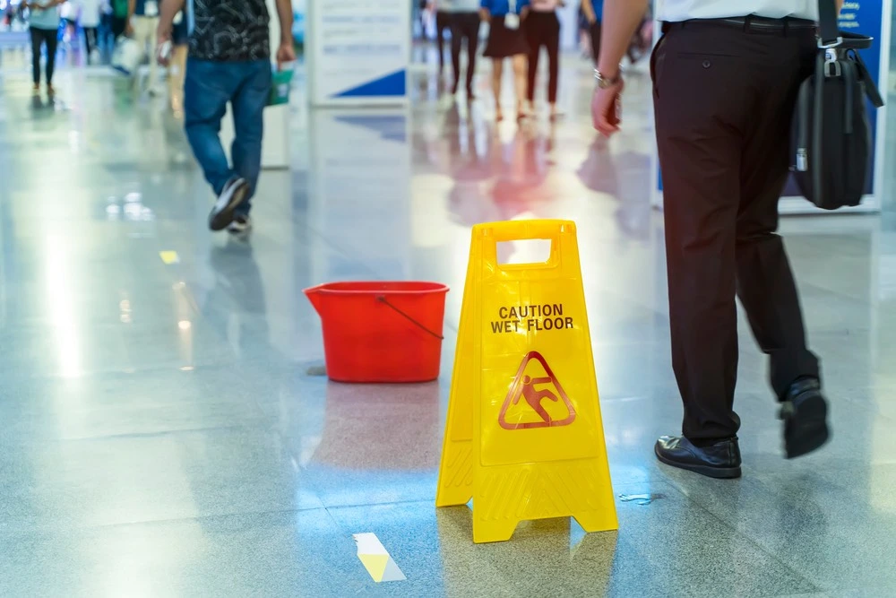 Wet floor caution sign on a slippery surface, illustrating where slip and fall accidents commonly happen in McAllen.