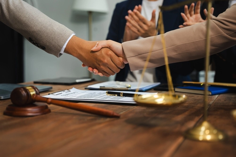Client shaking hands with a Rio Grande City personal injury lawyer in an office, representing Kenny Perez Law handling a personal injury case in Rio Grande City.