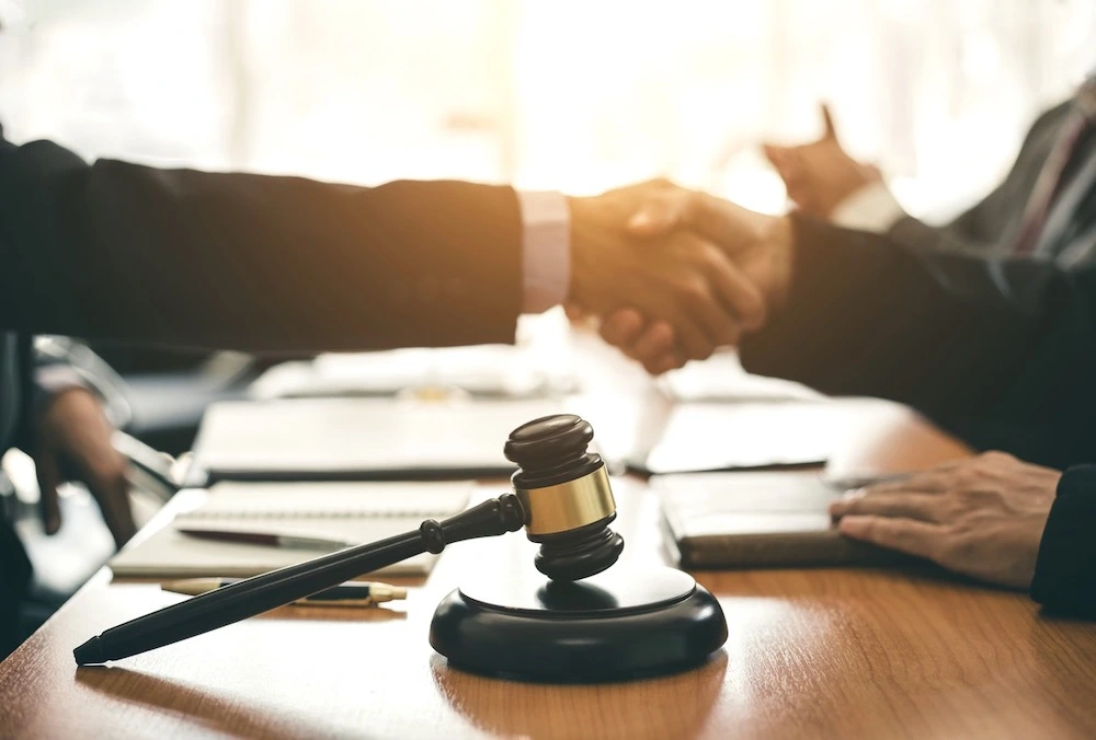 Client shaking hands with a South Padre Island personal injury lawyer in an office, representing out-of-state injury victims choosing Kenny Perez Law for trusted legal representation.
