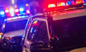 Escena de un accidente de tráfico con vehículos dañados y coches de policía acudiendo al lugar, que ilustra los diferentes tipos de accidentes de tráfico y los derechos legales de que disponen las víctimas lesionadas.